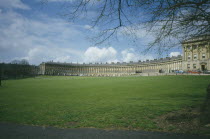 The Royal Crescent across grass area  budding branches frame