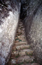 Stone steps leading up a narrow stone walled alleyway