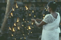 Lighting lamp beside Bo tree during Wesak festival.