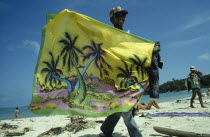 Sarong Vendor displaying colourful sarong on the beach
