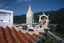 View over rooftop detail toward white tower with golden roof and spire