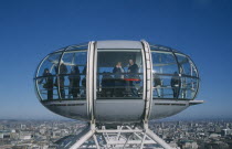 British Airways London Eye capsule and the London skyline with tourist waving to camera from the pod.
