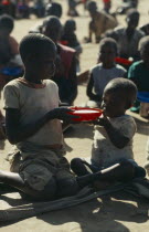 Children sharing bowl at feeding centre for displaced people run by World Vision Aid charity.refugee relationships Center