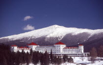 Mount Washington Hotel  large white building with red roof  snow peaked mountain behind.