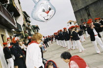 Basque riot policemen guard Basque suffragette marchers during the Alarde on 8 September. Child in push chair with rabbit balloon.