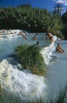 Tourists in terraced thermal pools.