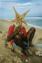 An elderly sea-shell seller returns to work 5 weeks after the Indian Ocean Tsunami hit Auroville Beach on December 26th 2004.starfishshells