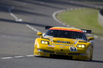 Number 63 yellow Corvette C5_R race car with advertising and logos  exiting the Porsche Curves.motor racing