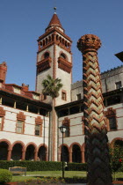 Flagler College  red and white brick building with tower with a water feature in the foreground