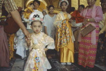 Group all dressed up for ordination ceremony Mahamuni Paya. Young girl in foreground. Great sage Pagoda.  Myanmar