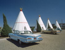 The Wigwam Motel made from stone with vintage cars parked outsidehotel