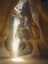 Sunshine rays shining through a hole in the slot canyon