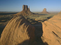 Rock formations with a golden sunset glow on the valley with rocks in the foreground