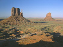Rock formations surrounded by desert in evening light