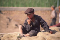 Tajik boy sat on sacks