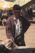 Tajik man with sheep for sale