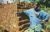 Portrait of man standing next  to brick building in a Ekhamuru Village.