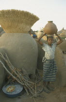 Near Garango. Young girl carrying water vessel on head.Girl called Mariam