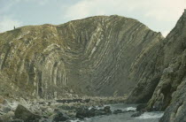 Coastal limestone cliffs with clearly defined folds.  Figure standing on top.