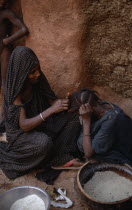 Woman braiding the hair of another.