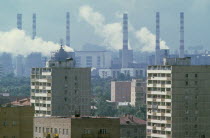 Smoke billowing from power station chimneys behind residential housing.air pollution  smog