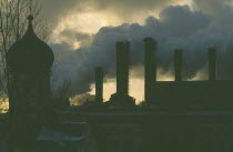 Onion dome roof of the Kremlin with smoke billowing from power station chimneys behind.air pollution  smog