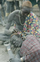 Dinka man having his hair dyed using cattle urine.