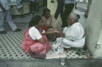 Sidewalk palm reader with women customers on Seragoon Street.
