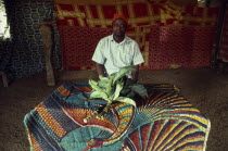 Leopard Cult elder sitting inside Ekpe house with spiritually charged leaves.