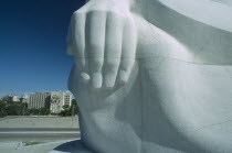 Detail of the hand of the Jose Marti statue with the Revolution Square below and the Ministry of the Interior building in the distance with the Che Guevara mural.