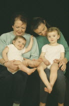 Portrait of grandmother  daughter and grandchildren aged thirteen months and two years old.  Three generations.