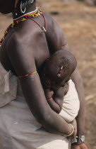 Baby carried in sling on mothers back  both wearing bead jewellery.