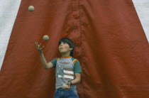 Child juggling three balls.