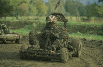 Mud covered competitor in rally kart six hour charity endurance race held to raise funds for motor sports association for the disabled.