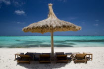 Palapa thatched shelter and sunbeds on Godahl Beach at Raffles Resort