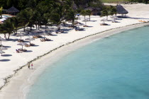 Two women walking along Jambu Beach at Raffles Resort