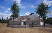 Kensington Gardens.  The Serpentine Gallery exterior with visitors standing beside railings at the entrance.