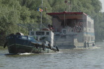 Boat with tourists towed by a tug in Danube Delta Biosphere ReserveUNESCO heritage site