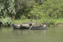Fisherman transporting cycle and goods in a country boat in Danube Delta Biosphere ReserveUNESCO heritage site