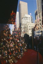 Fifth Avenue window display showing brightly decorated christmas tree with people looking in from the street