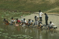 Near the China plain. People washing their clothes in the river.