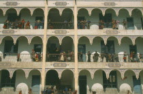 Uygur schoolchildren on balconies of multi-storey building.