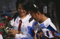 Phra Pokklao.  St Valentines day with two Thai school girls in uniform buying roses from outside High School.