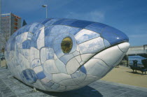 Sculpture of fish next to Lagan Weir footbridge. Designs use Lasertran photocopies of old newspaper clippings.