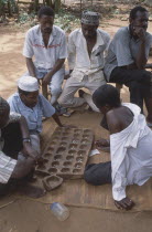 Group of young men playing traditional board game.
