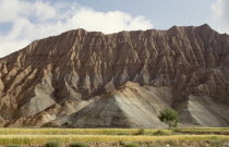 View of soft eroded rocks above a wheat field in a remote valley near the Yellow River.
