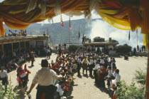 Dancers at Tibetan festival seen through canopy