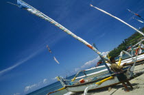 Outrigger sailboats on the beach with fisherman