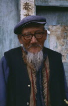 Portrait of a Naxi man with cap and glasses