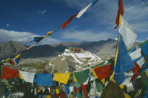 View across valley through prayer flags towards the Potala set on the top of a hill